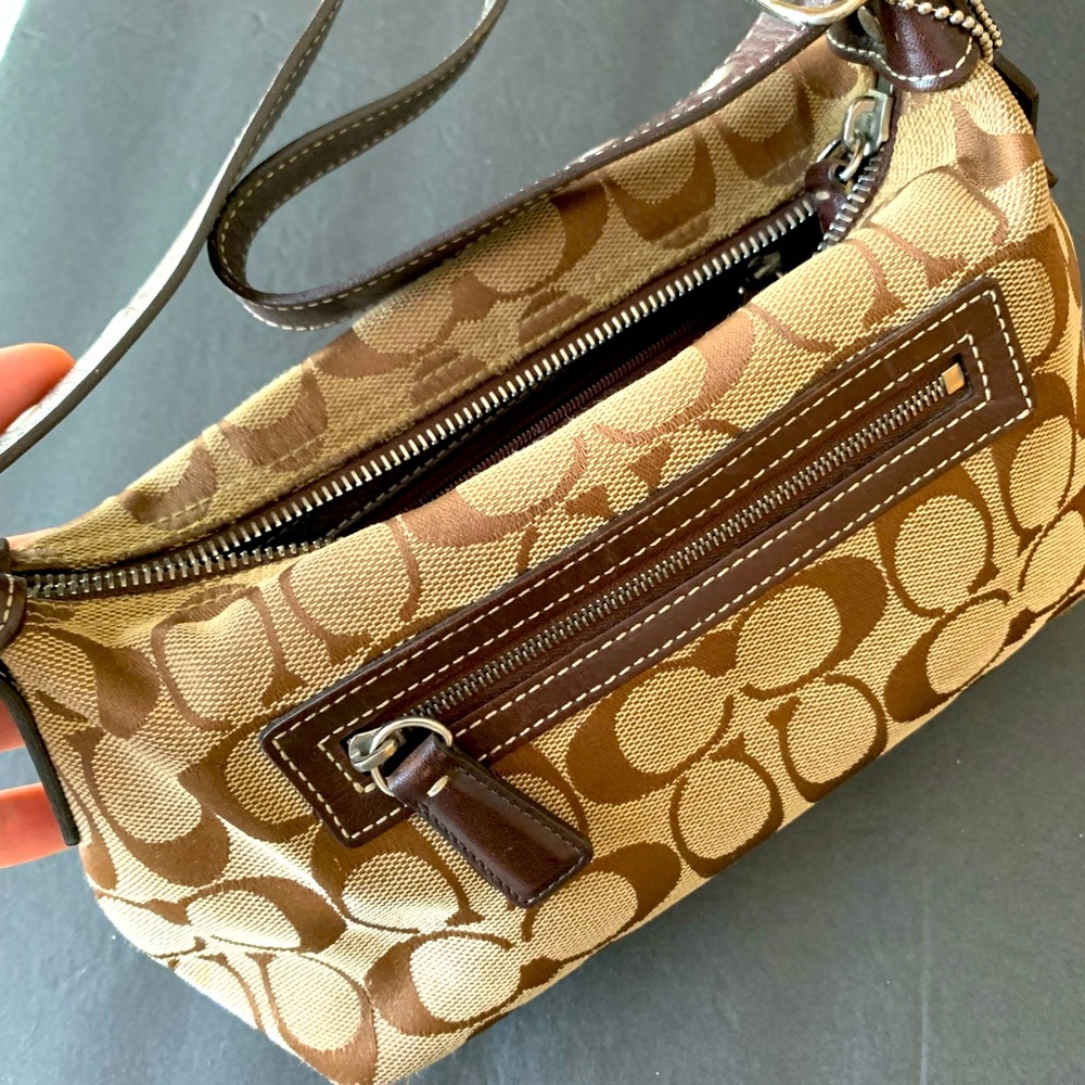 COACH Small brown clutch purse with logo tag.